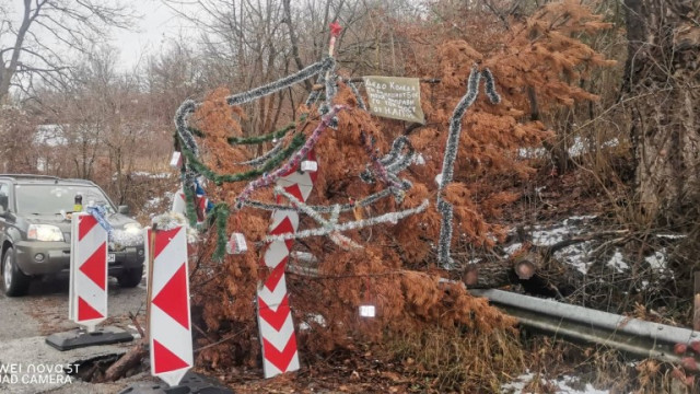 Коледна елха грейна пред огромна дупка на оживен републикански път